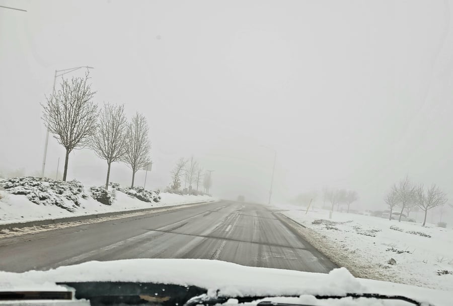 Foggy, snowy road from car window